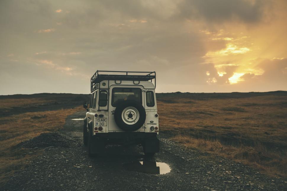 Free Image of Rear view of vehicle traveling on a remote dirt road 