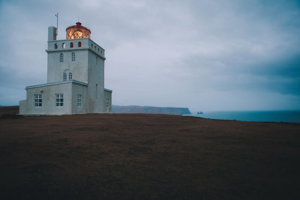Free Image of Solitary lighthouse on cliff by the sea at dawn. 