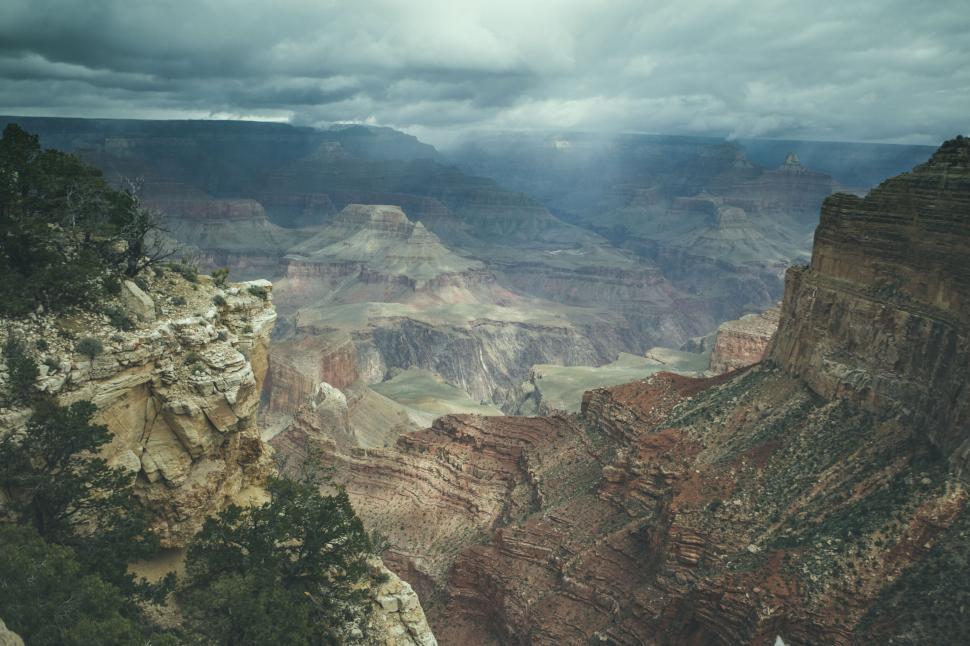 Free Image of Grand Canyon s vast layers under dramatic cloudy sky. 