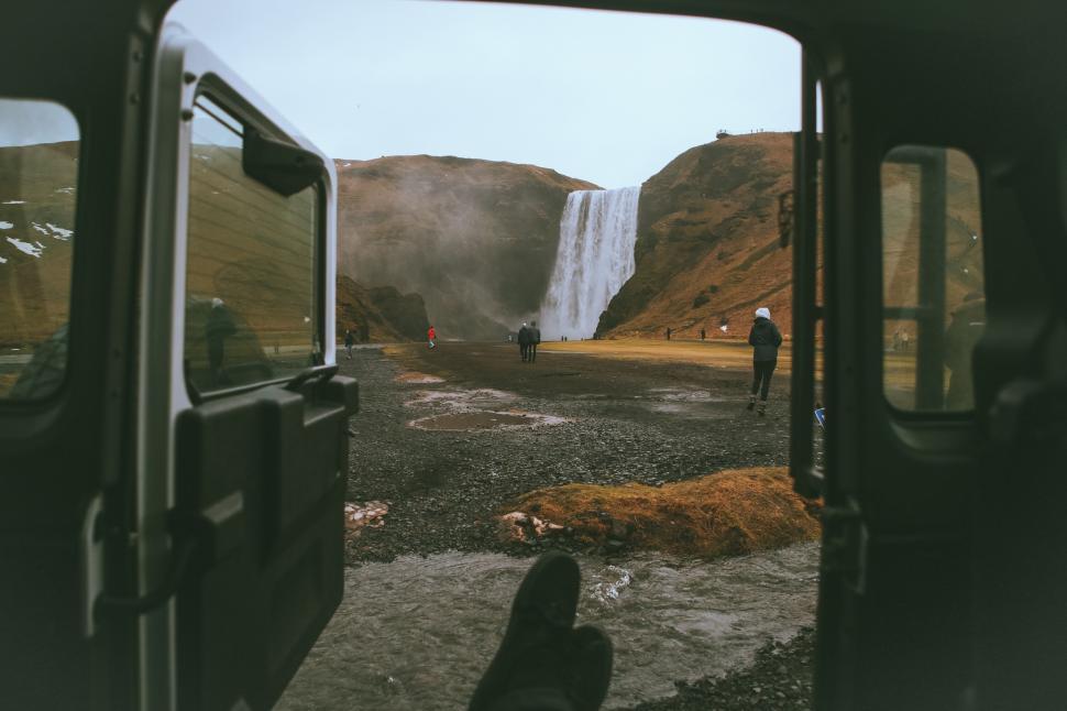 Free Image of View of waterfall through an off-road vehicle back door 