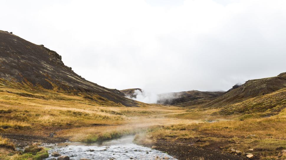 Free Image of Scenic Valley with Steam and Hills in the Distance 