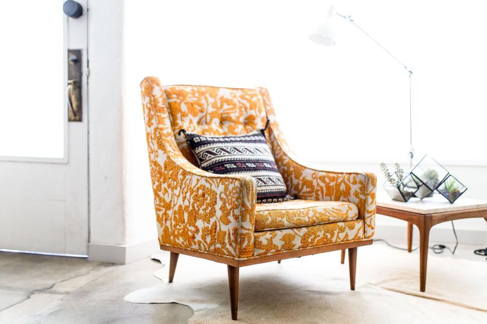 Free Image of Orange patterned chair in modern living room setup. 