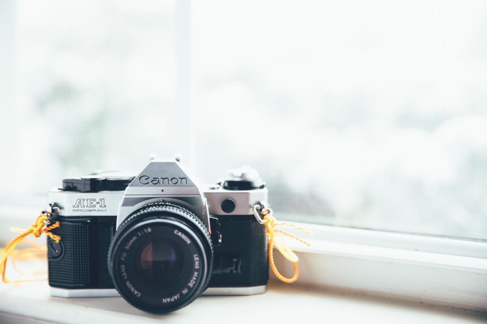 Free Image of Vintage Canon AE-1 camera sitting by a bright window 