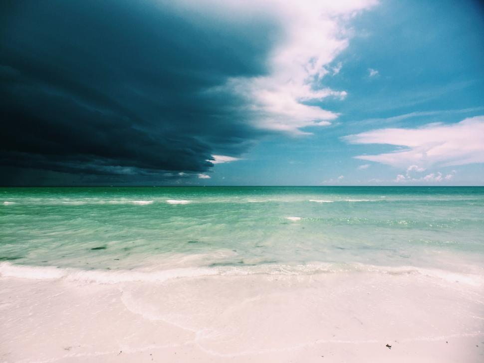 Free Image of Imposing storm clouds over the clear turquoise ocean. 
