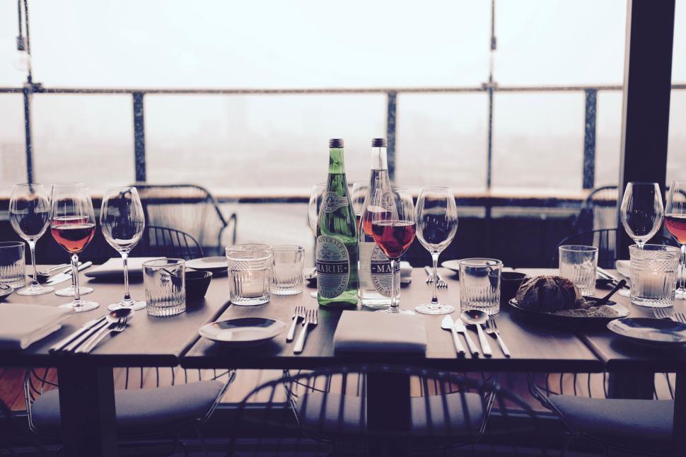 Free Image of Elegant dining table setup with glasses and wine bottles 