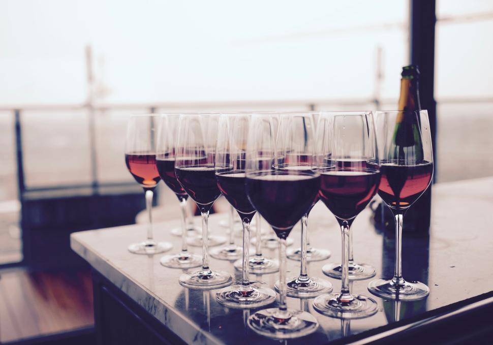 Free Image of Several glasses of red wine on a modern table outdoors 
