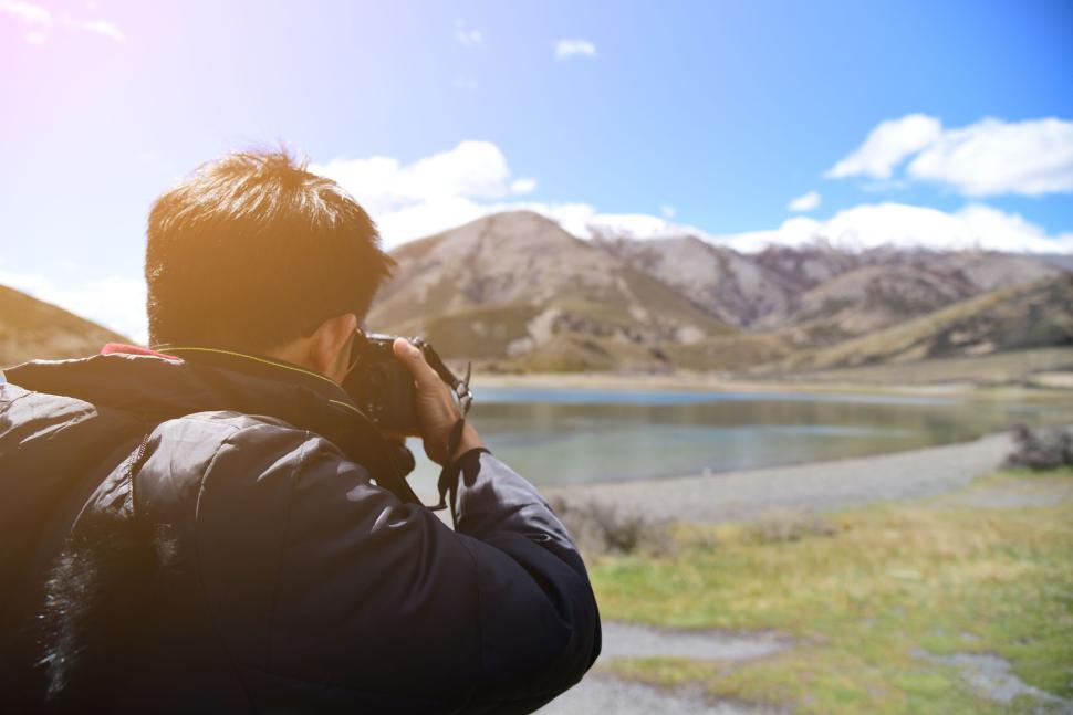 Free Image of Photographer taking a picture of a scenic mountain lake. 