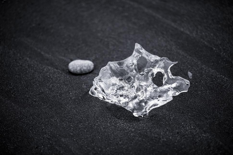 Free Image of Piece of ice on black sand beach symbolizing contrast 