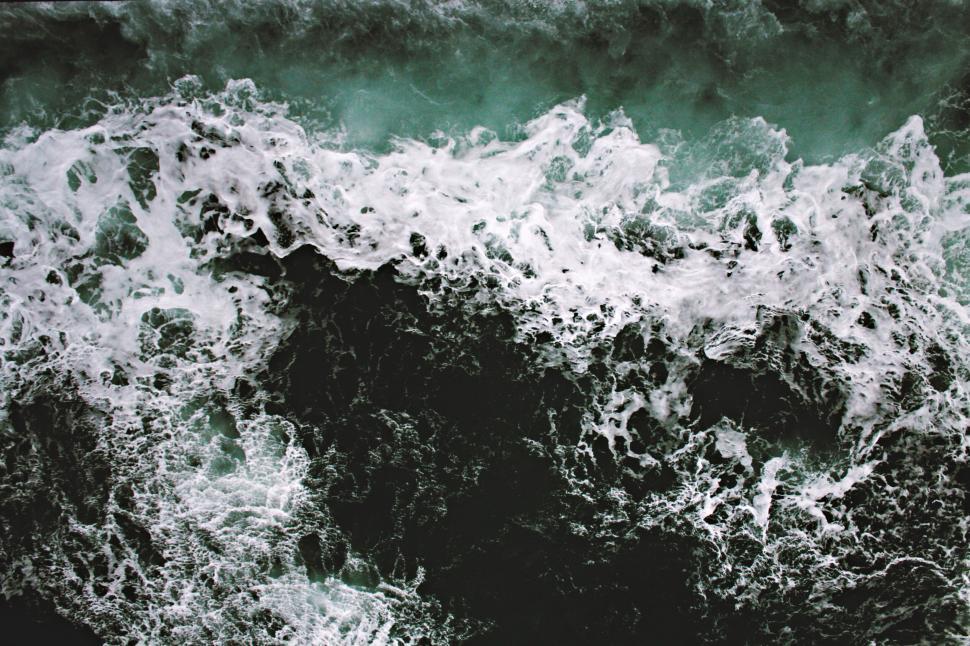 Free Image of Dynamic ocean waves crashing with swirling white foam 