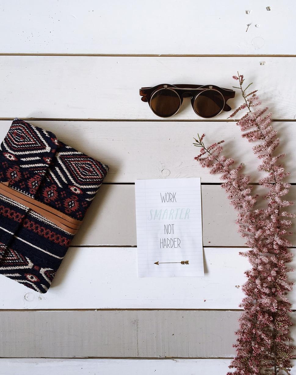 Free Image of Flat lay with glasses, notebook, flower, and quote card. 
