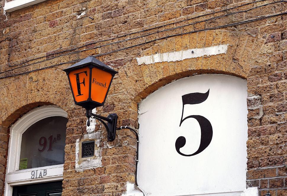 Free Image of Number 5 door and lantern on brick building wall. 