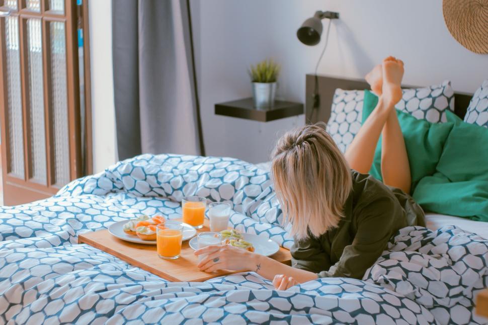 Free Image of Woman enjoying breakfast in bed on a cozy morning. 