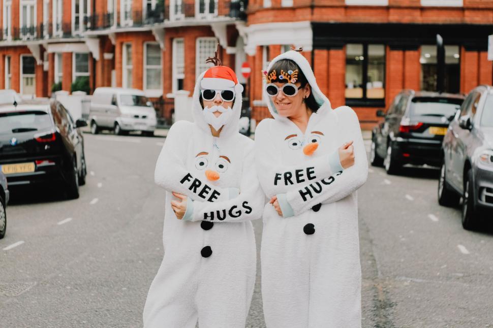 Free Image of People in snowman costumes offering free hugs on the street 