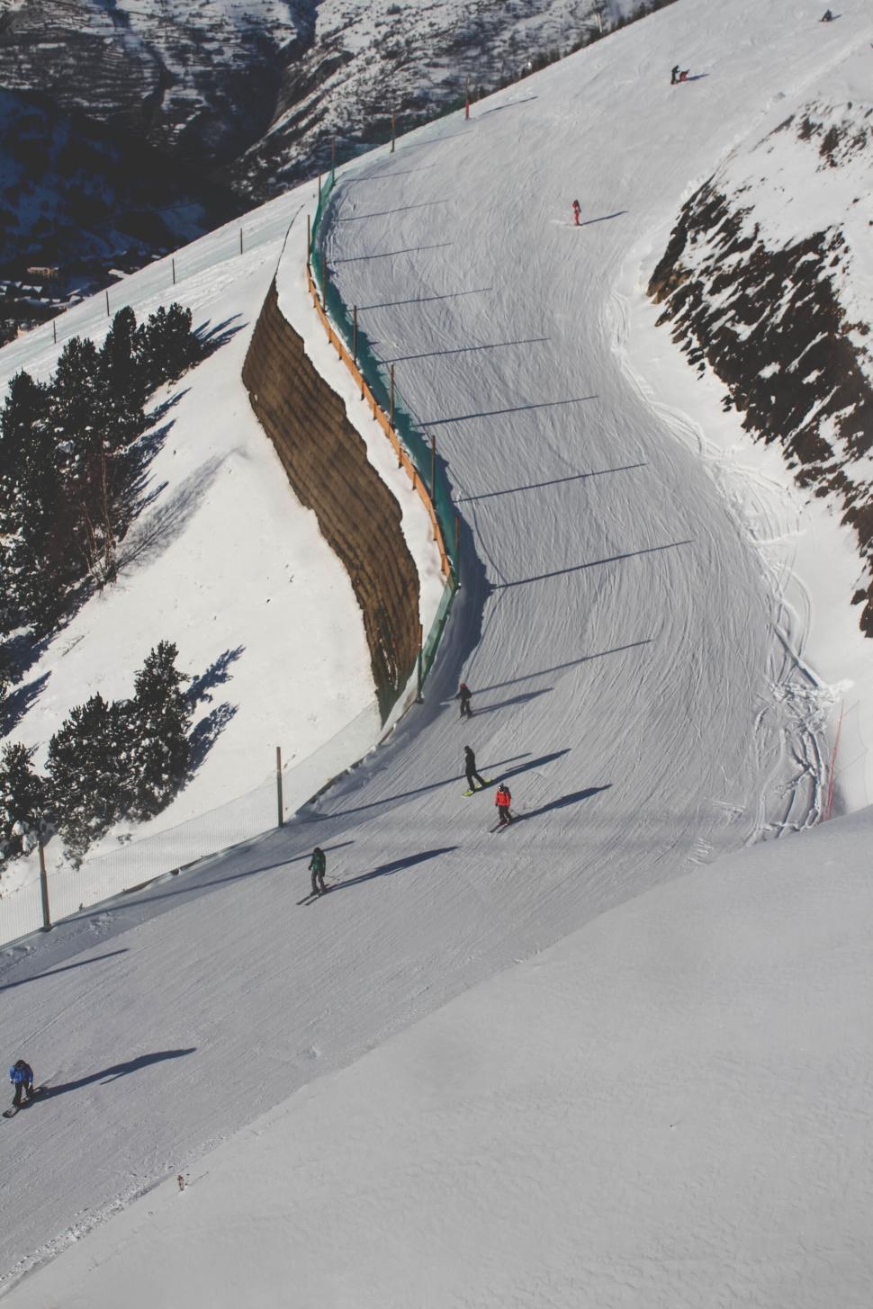 Free Image of Scenic view of skiers on a snowy mountain curve. 