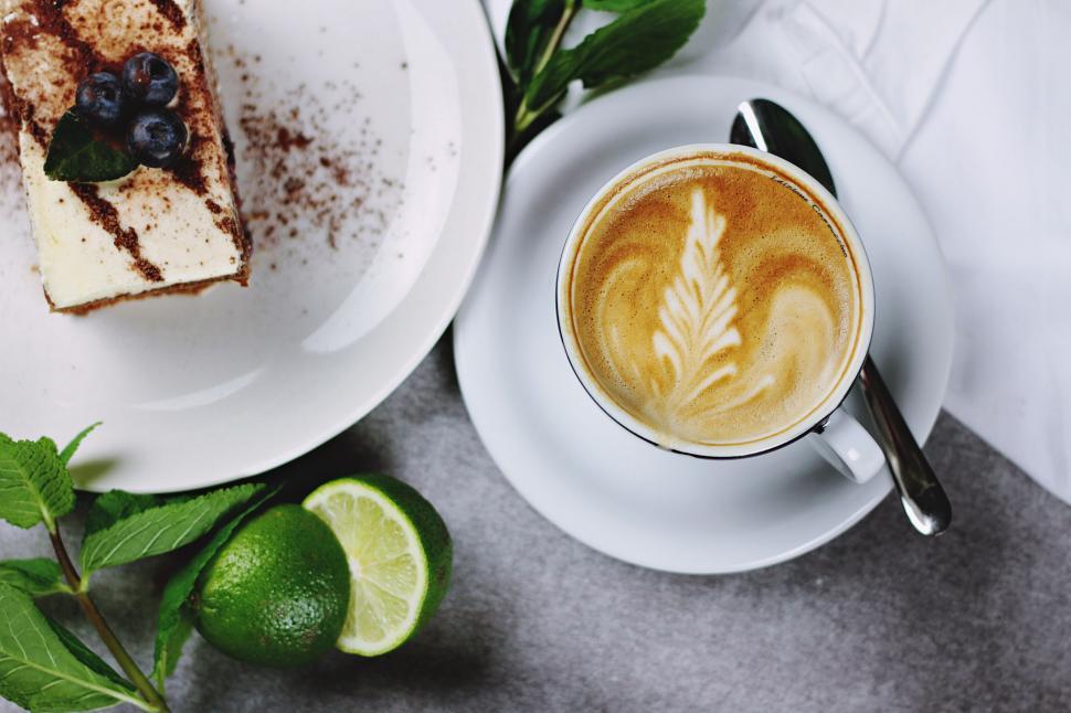 Free Image of Coffee cup and dessert with fresh limes and greens. 