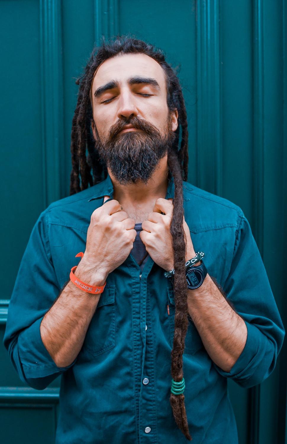 Free Image of Man with dreadlocks meditating with closed eyes outdoors 