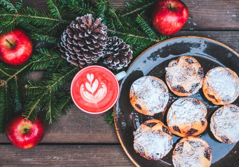 Free Image of Festive treats with red coffee and pine decorations. 