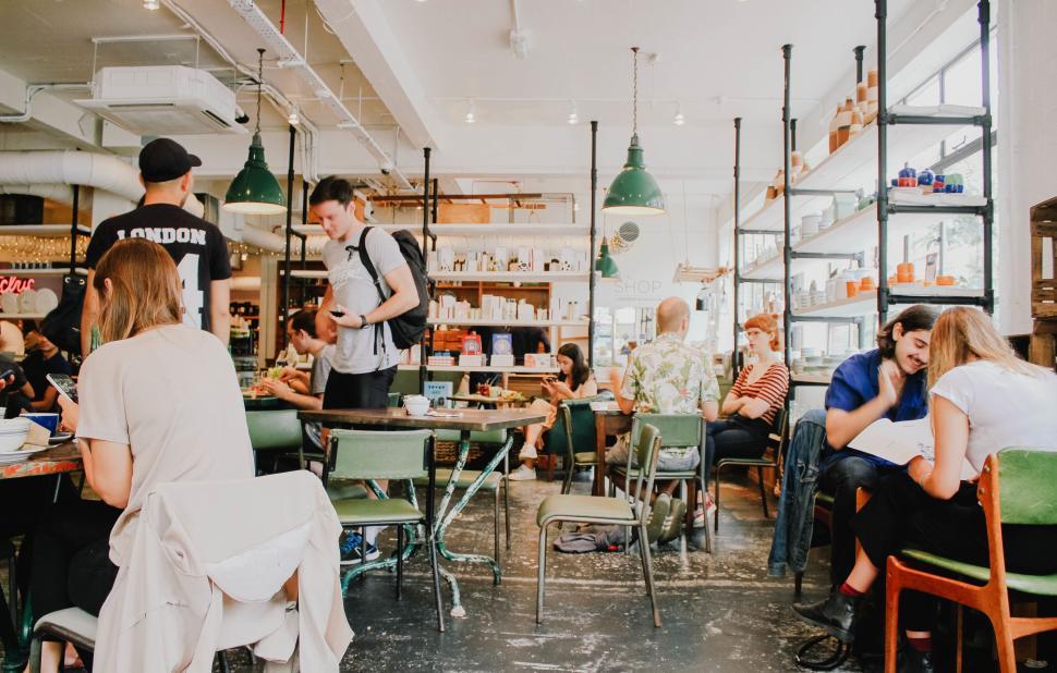 Free Image of People socializing and working in a cozy cafe setting. 