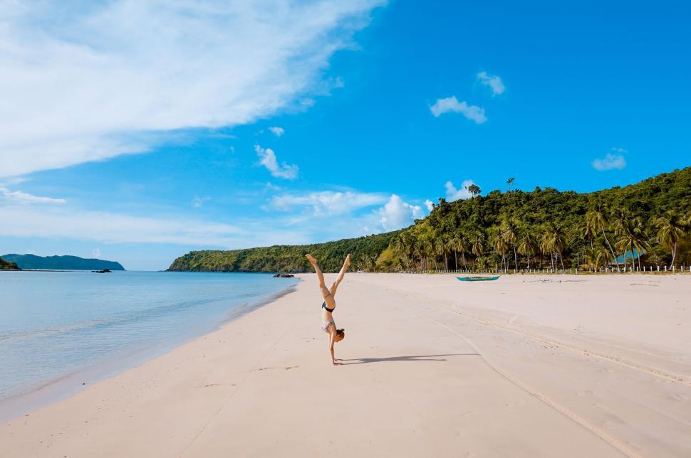Free Image of Person performing handstand on beautiful beach view. 