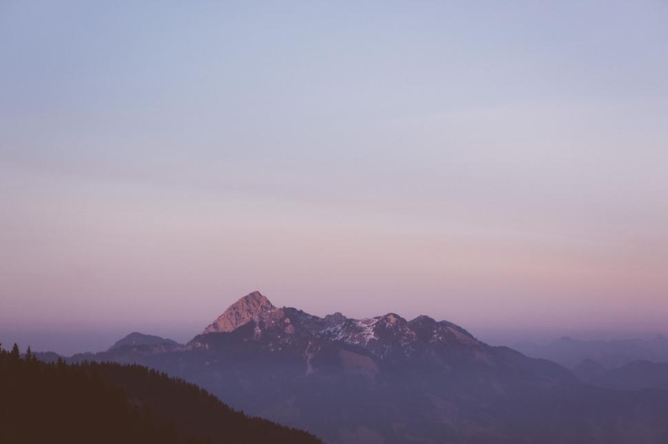Free Image of Distant mountain peak under soft purple sunrise 