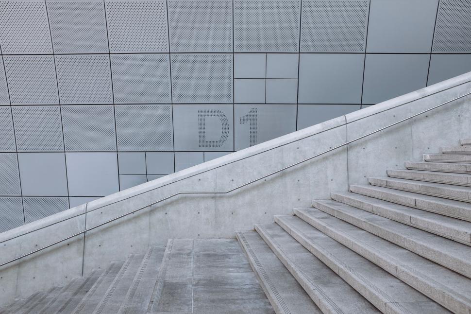 Free Image of Modern stairway adjacent to light grey tiled facade design. 