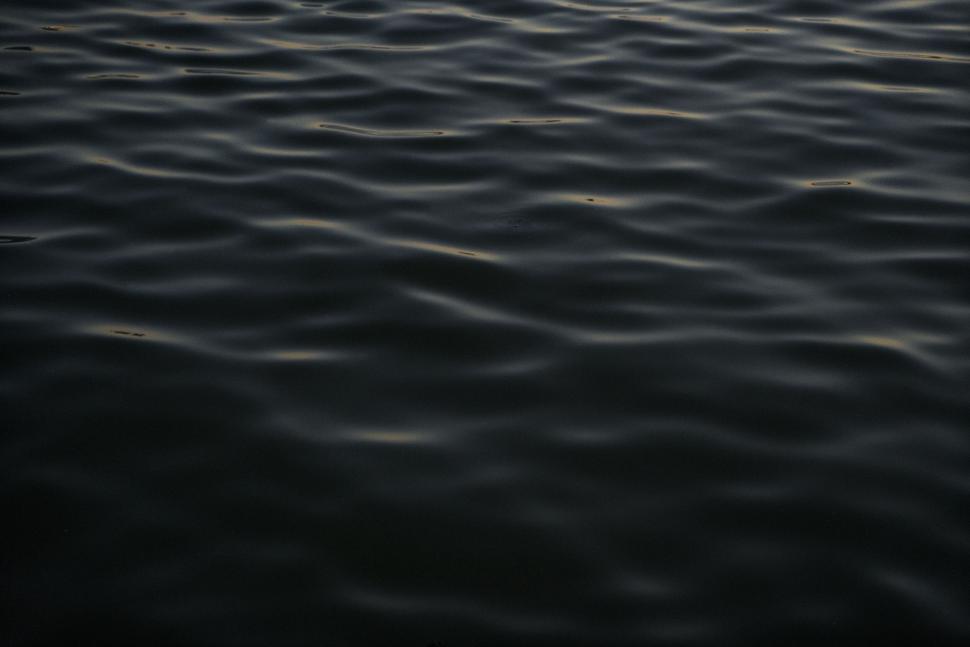 Free Image of Calm water surface with gentle ripples at dusk. 