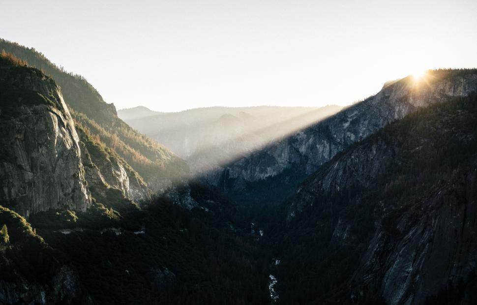 Free Image of Sunrise illuminating mountain valley with rays of sunlight. 