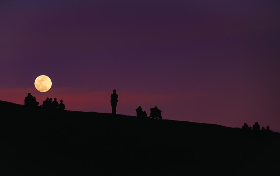 Free Image of Silhouette of people watching full moon at dusk. 
