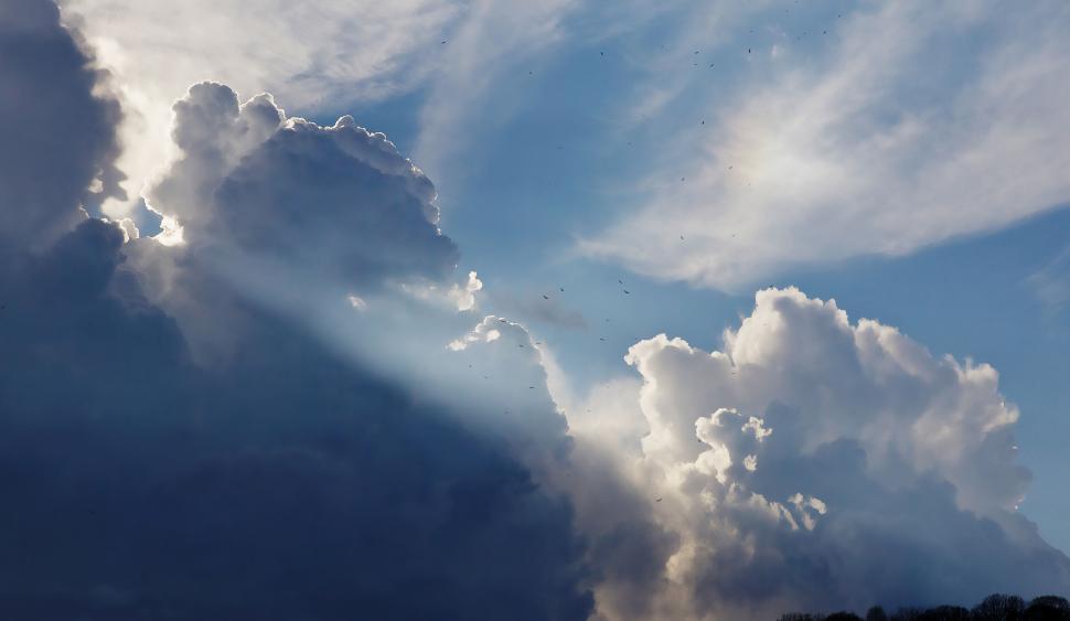 Free Image of Dramatic cloud formations with light rays breaking through 
