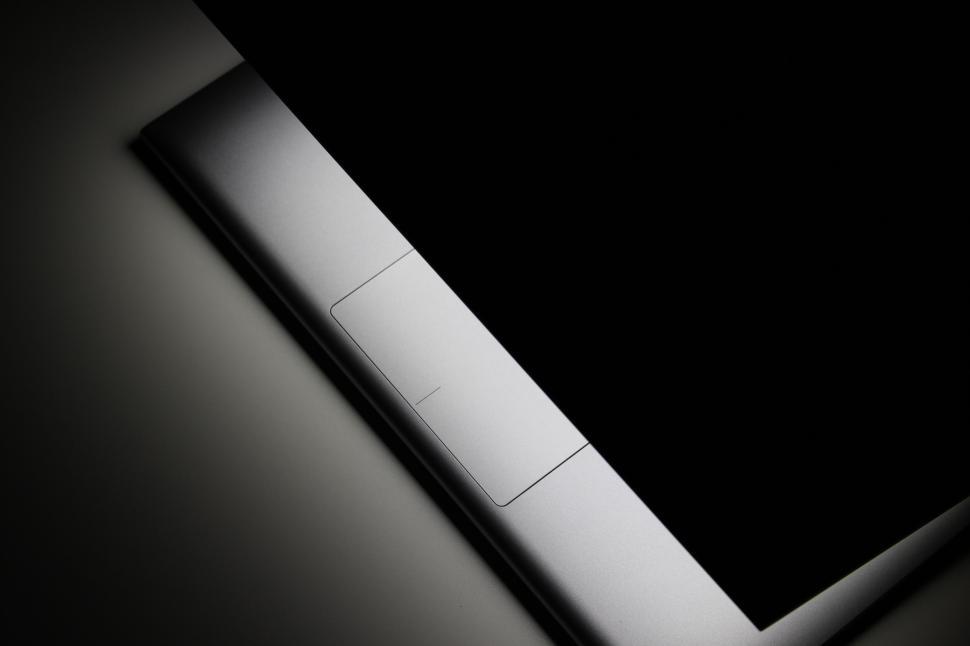 Free Image of Partially opened laptop in a dark environment showing light. 