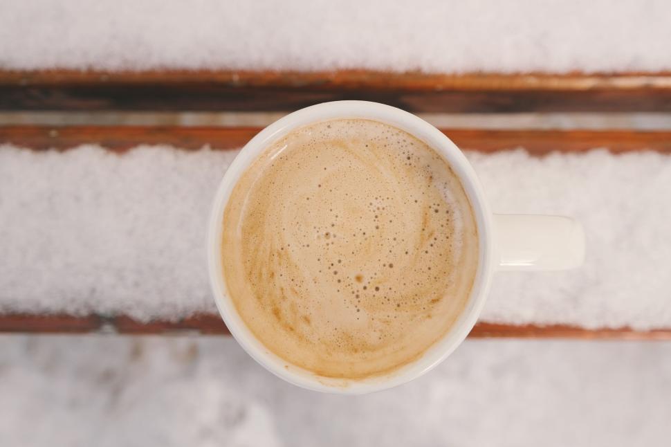 Free Image of Top view of a coffee cup on a snow-covered bench 