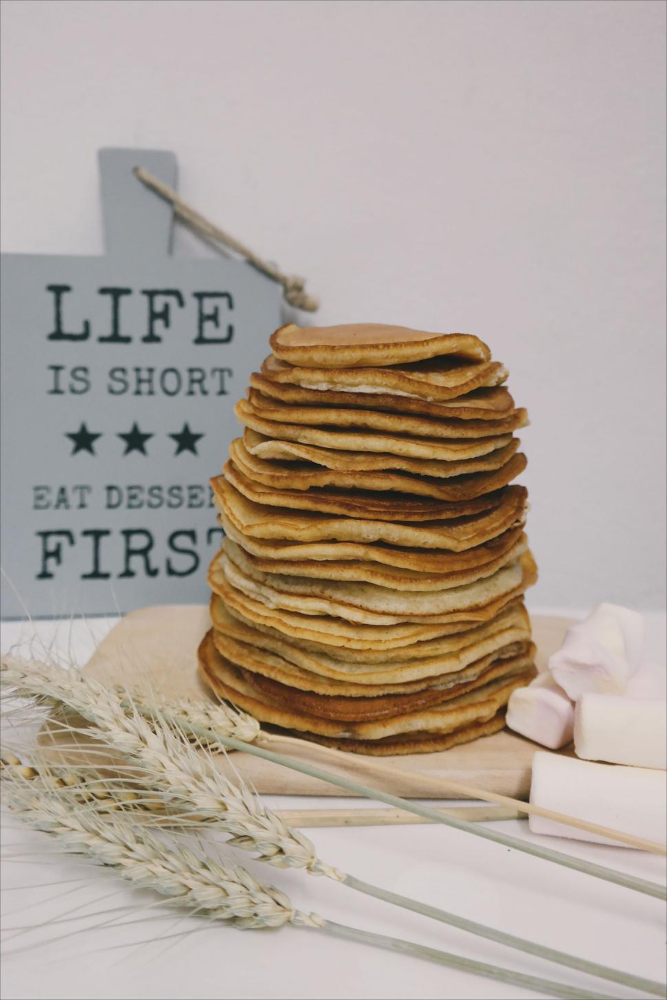 Free Image of Stack of pancakes next to a sign with a catchy phrase 