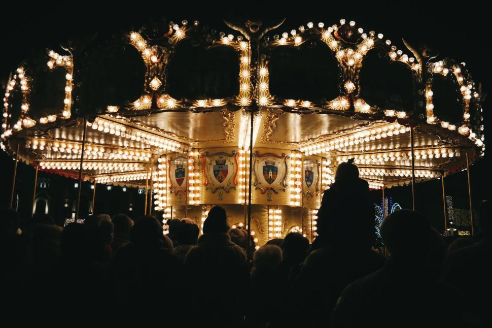 Free Image of Brightly lit carousel at night with a crowd. 