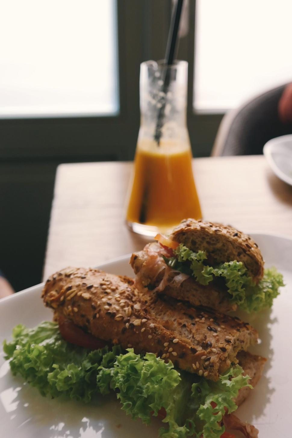 Free Image of Healthy sandwich and glass of orange juice on table 