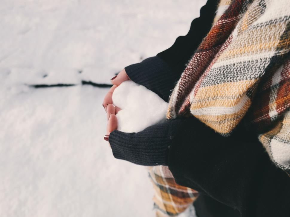 Free Image of Person holding snow in winter with a plaid scarf on. 