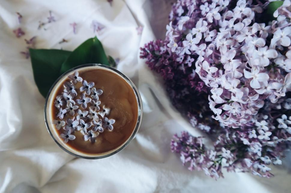 Free Image of Iced coffee with lilac flowers on a white cloth 