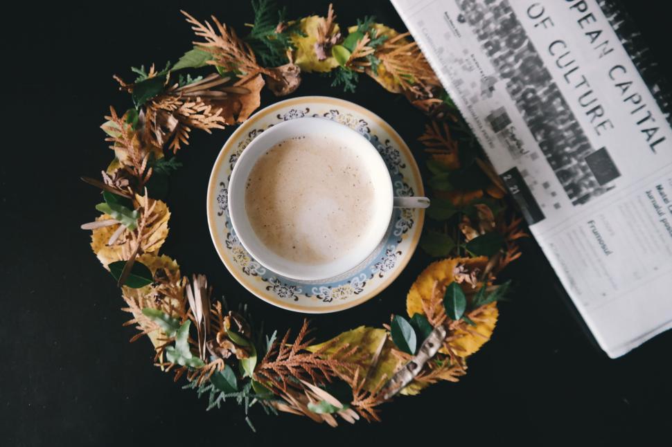 Free Image of Cup of coffee surrounded by autumn leaves and newspaper 
