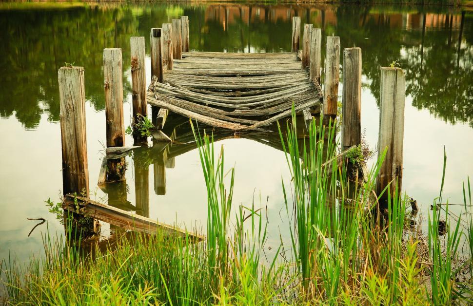 Free Image of Dilapidated wooden bridge over calm lake view 
