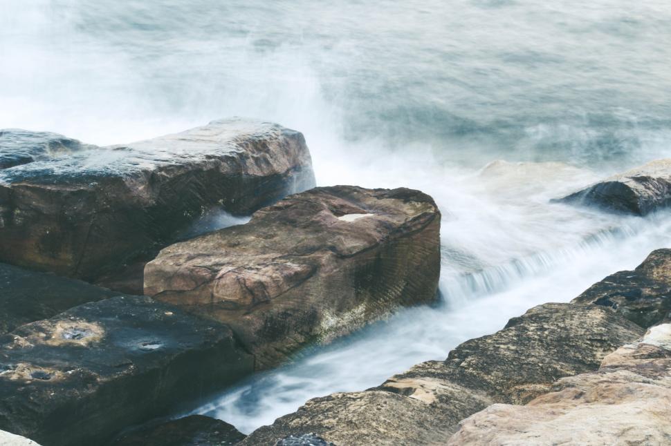 Free Image of Waves crashing on rugged rocky shoreline at seaside. 