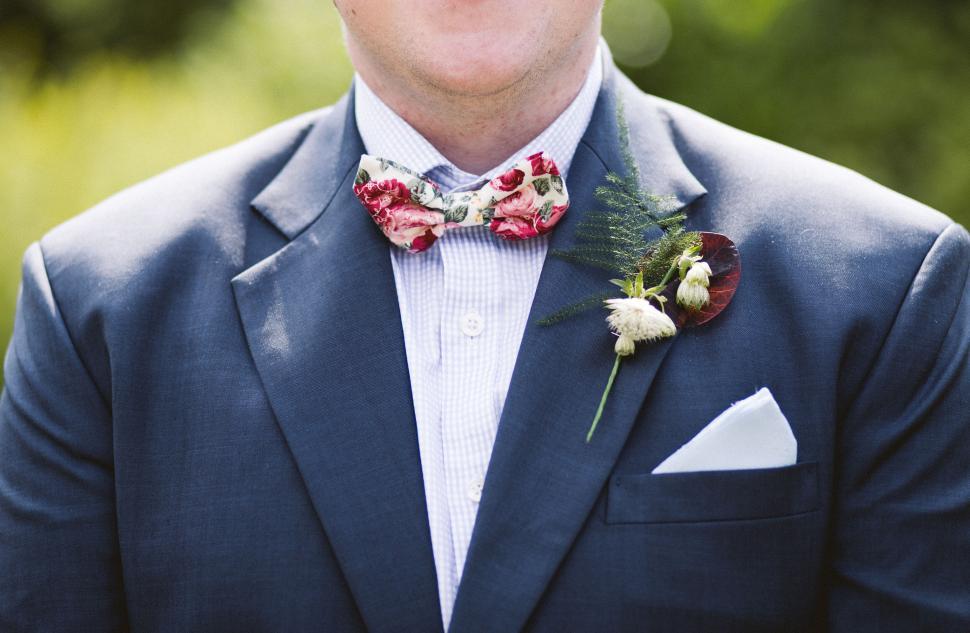 Free Image of Groom dressed in suit with colorful floral bow tie. 