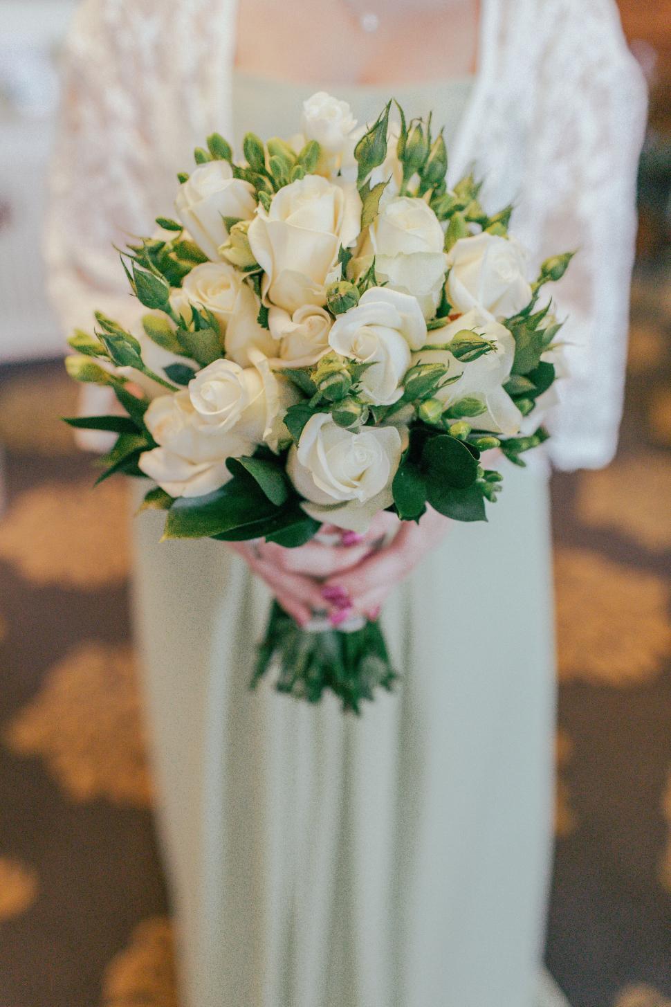 Free Image of Bridal bouquet of white roses held by a bridesmaid 
