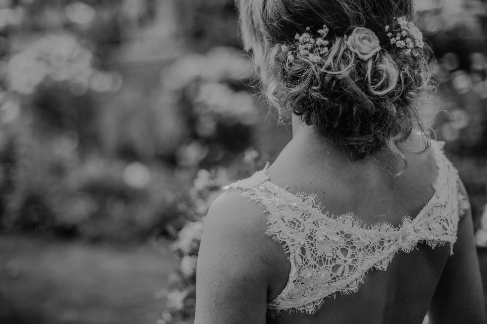 Free Image of Bride with floral hairpiece standing in a garden 