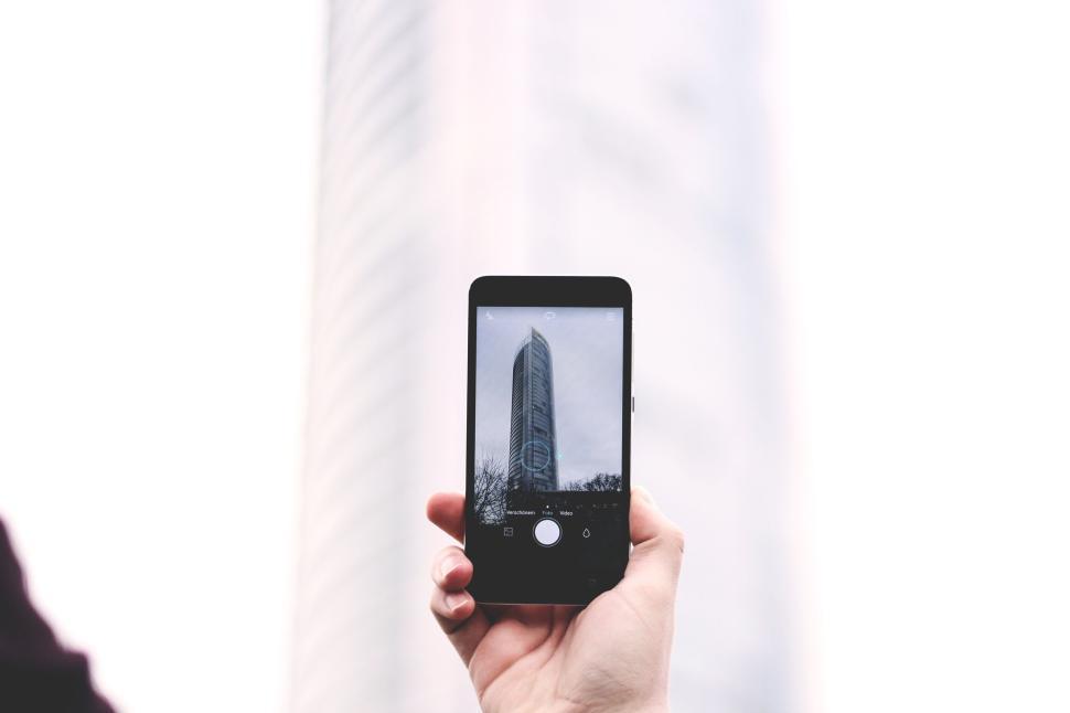Free Image of Hand holding smartphone with building on screen 