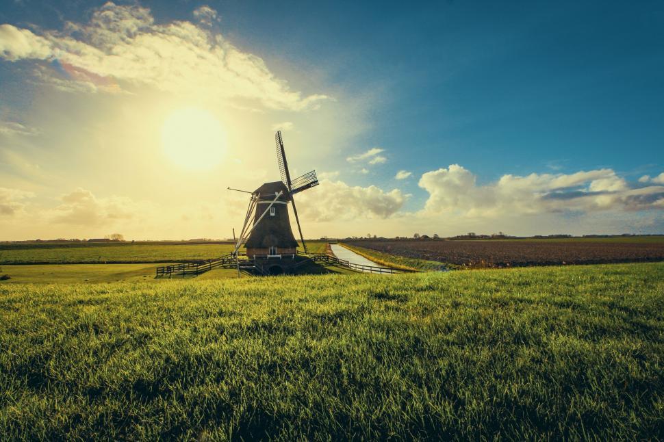 Free Image of Traditional windmill in a green field during sunset 