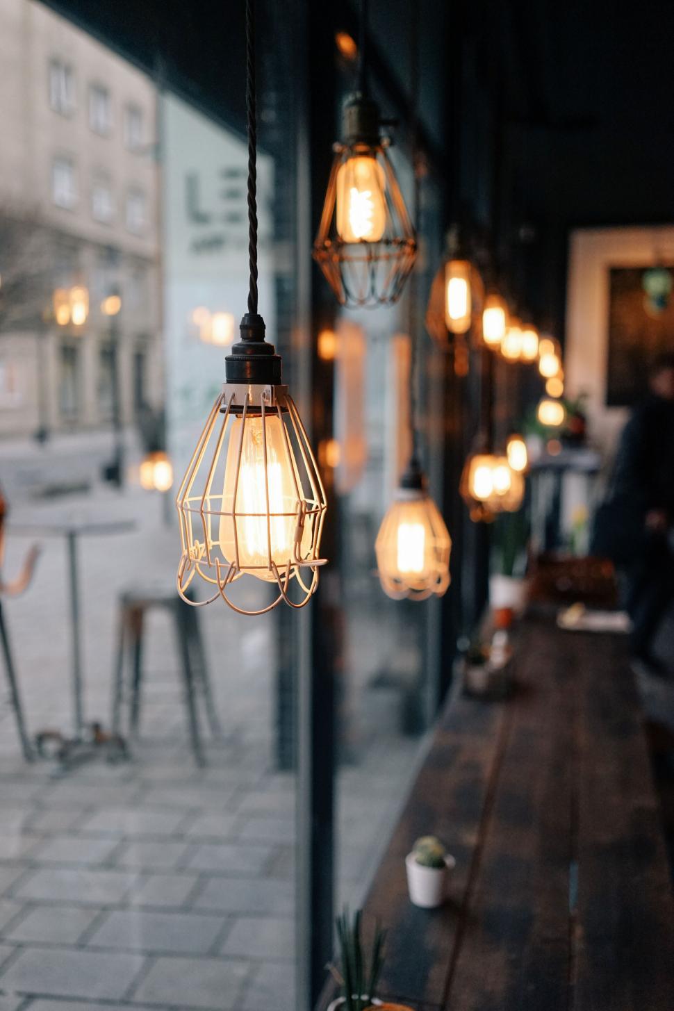 Free Image of Hanging lights illuminate cozy, rustic caf? at night. 