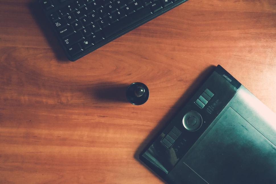 Free Image of Graphic tablet and keyboard on brown wooden surface. 