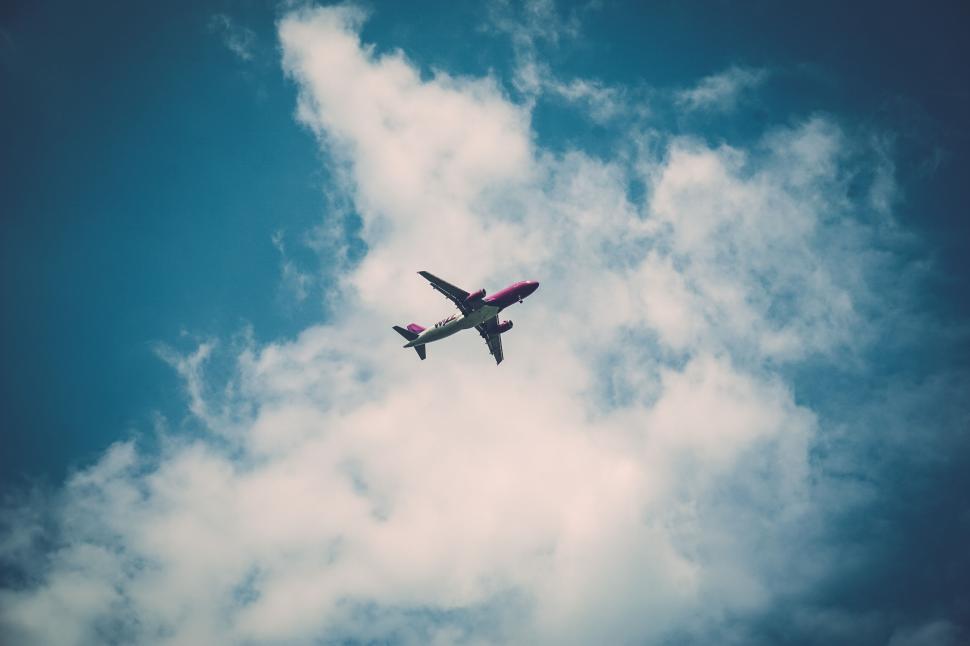 Free Image of Commercial airplane flying high above fluffy clouds. 