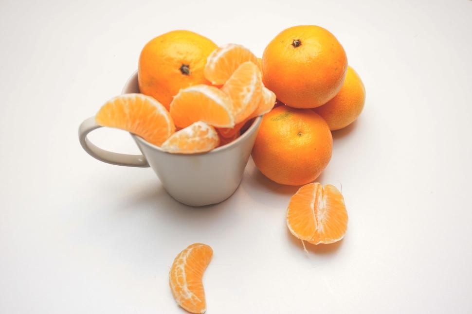 Free Image of Fresh oranges, peeled segments served in a white cup 