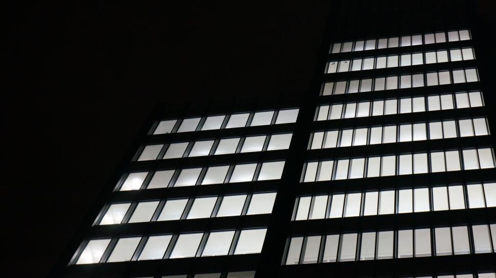 Free Image of Lit windows of a dark building against night sky view. 