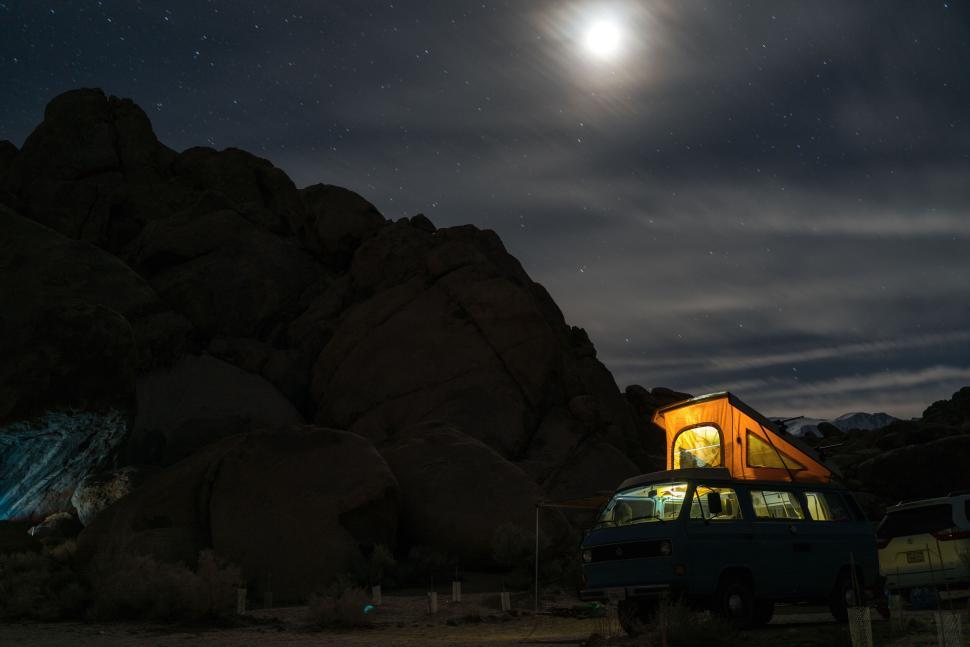 Free Image of Night camping with lighted van under a full moon sky. 